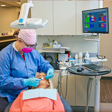 Dental assistant examines a patient's teeth