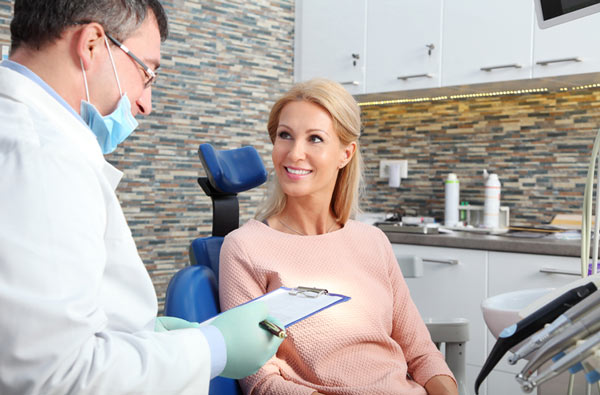 Woman talking to a dentist during her dental exam at Singing River Dentistry.