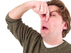 Man pinching nose because something has extremely bad breath